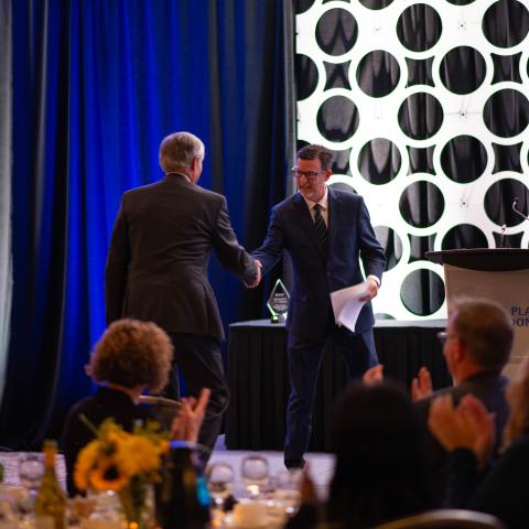 Darrin Pollard shakes hands with an ambassador award recipient